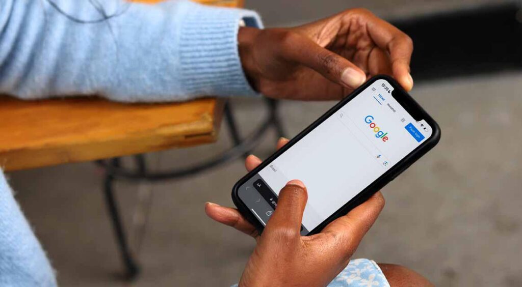 Imagem de uma mulher pesquisando no google como Ranquear site